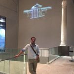 Hall du musée de la romanité. Pose devant une des colonnes du nymphée, et animation 3D en arrière-plan